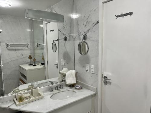 a bathroom with a sink and a mirror at Center Suiço Flats in Campos do Jordão