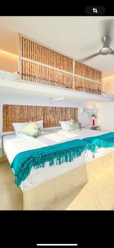 a bedroom with a large bed with a blue blanket at Laguna Beach, Brisa Marina playa Frances in Coveñas