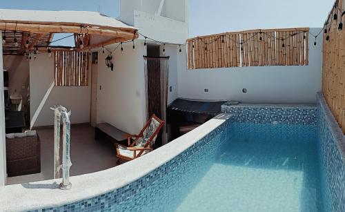 a large swimming pool with a chair in a room at Apartamento de playa y piscina, Mejia in Mejia