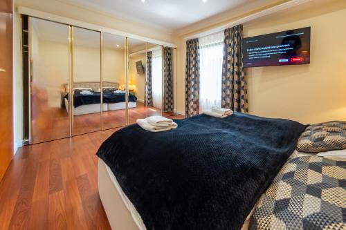 a bedroom with a large bed and a tv on the wall at Willowa 21 in Wisła