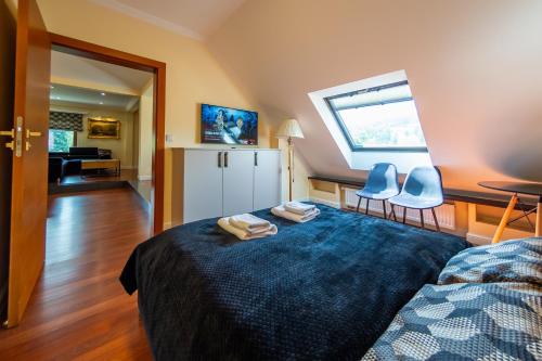 a room with a bed and two chairs and a kitchen at Willowa 21 in Wisła