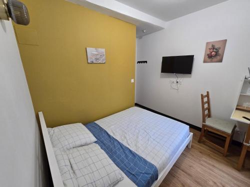 - une petite chambre avec un lit et une télévision dans l'établissement E0 - Beau studio en intramuros, rénové climatisé, à Avignon