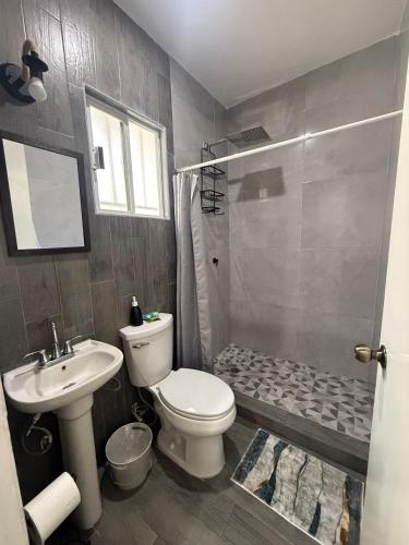 een badkamer met een toilet, een wastafel en een douche bij Casa Naay in Cancun