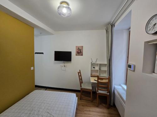 une chambre avec un lit, une table et une télévision dans l'établissement E0 - Beau studio en intramuros, rénové climatisé, à Avignon