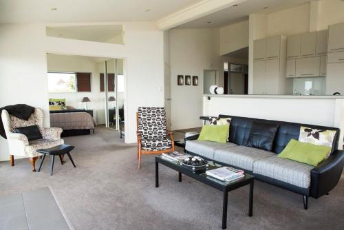 Waiheke IslandにあるView43 Beach Houseのソファとテーブルのあるリビングルーム