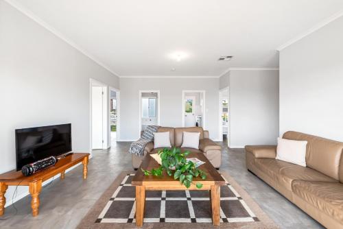 a living room with a couch and a table at Seven by the Sea in Kingscote