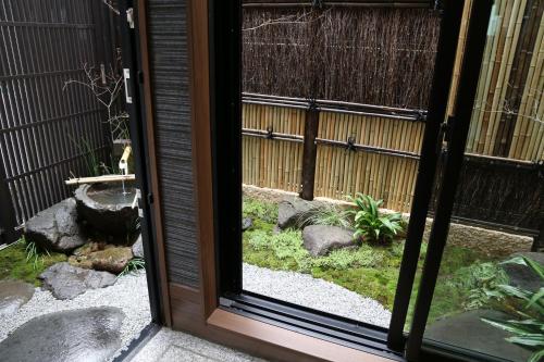 a door leading to a garden with rocks and plants at Bliss INN Kuromon ブリスイン黒門 in Osaka