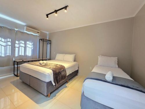 a bedroom with two beds and a window at Casa Ampla 5 quartos área lazer TOP lado Paraguai in Foz do Iguaçu