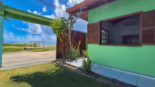 a green building with a view of the beach at Flat, Refúgio Beira Mar in Santa Cruz Cabrália