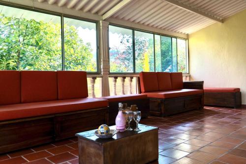 a waiting room with red benches and windows at Finca alto Bonito Jacuzzi Piscina y WiFi in Tenza