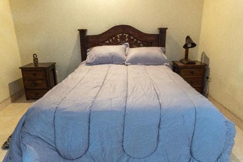 a bedroom with a blue bed with two night stands at Finca alto Bonito Jacuzzi Piscina y WiFi in Tenza