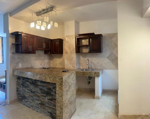 een keuken met een stenen aanrecht en houten kasten bij Edificio La Paz in Puerto Vallarta