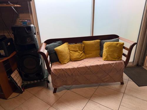 a couch with yellow pillows in a living room at residence caramboles in Fort-de-France