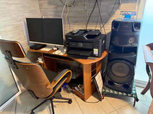 a desk with a computer and a printer and a speaker at residence caramboles in Fort-de-France