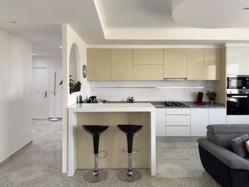 a kitchen with a counter with two stools at Spacious 3-bdr apartment - Palmarejo Grande - LCGR in Praia