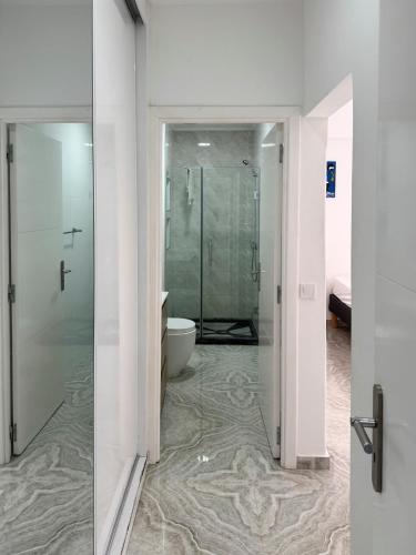 a bathroom with a glass shower and a toilet at Spacious 3-bdr apartment - Palmarejo Grande - LCGR in Praia