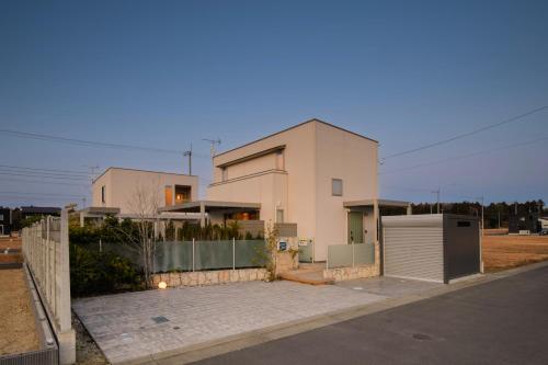 a white house with a fence in front of it at Pool Villa Mito - Pool Villa 水戸 in Mito