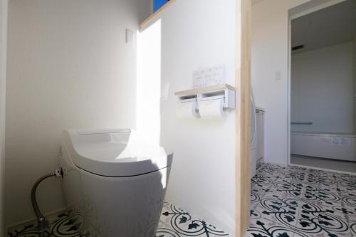 a bathroom with a toilet and a tile floor at Pool Villa Mito - Pool Villa 水戸 in Mito