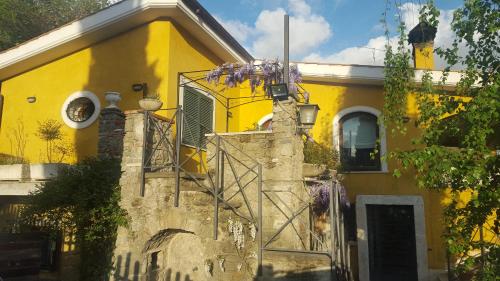 a yellow house with a staircase in front of it at Il Nido del Falco in Castel Gandolfo