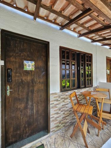 a wooden door to a patio with a table and chairs at Ilha Grande Inn in Abraão