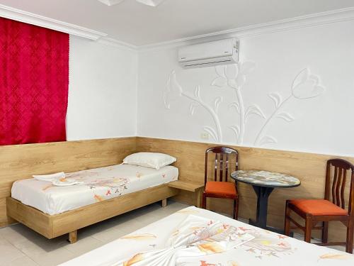 a room with two beds and a table and chairs at Villa Kasa in Durrës