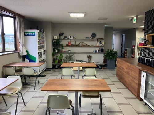 一関市にあるアットビジネスホテル一関の部屋にテーブルと椅子があるレストラン