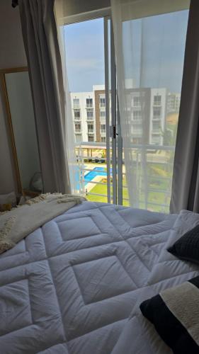 a bedroom with a bed and a large window at Departamento en Acapulco de Juárez, Club de Playa in Acapulco