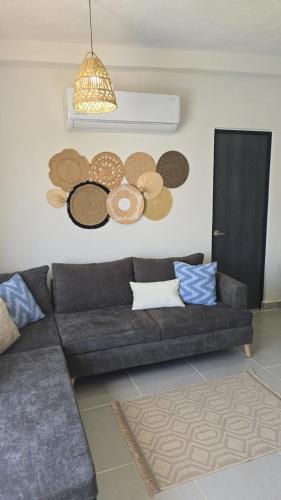 a living room with a couch and some hats on the wall at Departamento en Acapulco de Juárez, Club de Playa in Acapulco
