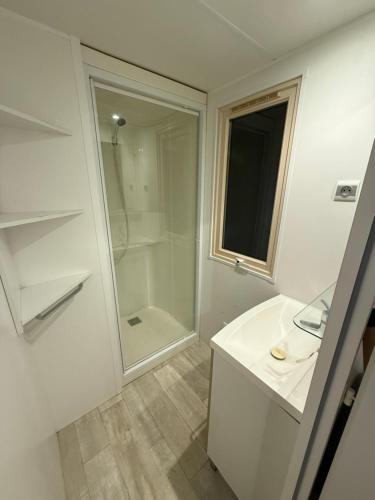 une salle de bain blanche avec une douche et un lavabo dans l'établissement Neptune 158 Argeles, à Argelès-sur-Mer