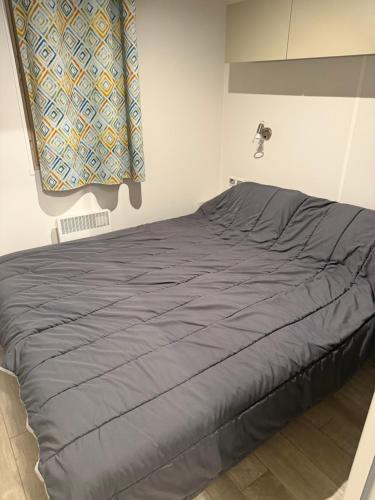 Ce lit se trouve dans une chambre dotée d'une couverture bleue. dans l'établissement Neptune 158 Argeles, à Argelès-sur-Mer