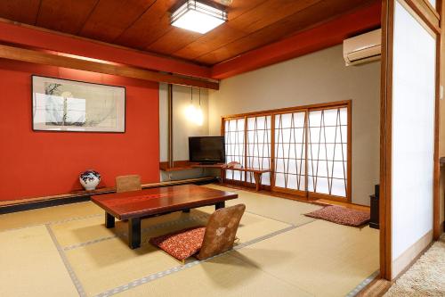a living room with a wooden table and chairs at Yanagiso in Toyooka