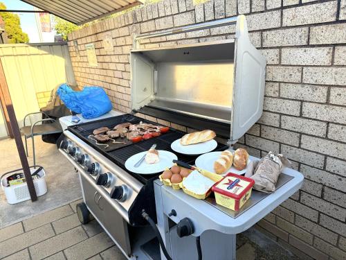 a grill with meat and other food on it at Cowra Crest Motel in Cowra