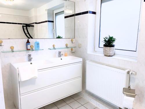 a white bathroom with a sink and a mirror at Kompakt & Ruhig - Nähe Hannover Messe in Hannover