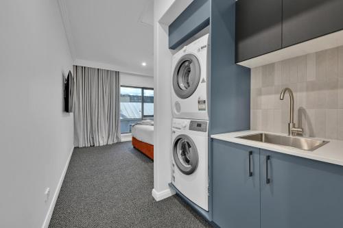 a laundry room with a sink and a washer and dryer at The Mac in Orange