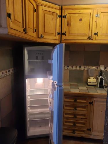 an empty refrigerator with its door open in a kitchen at Departamento Jardín Magnolia in Apizaco