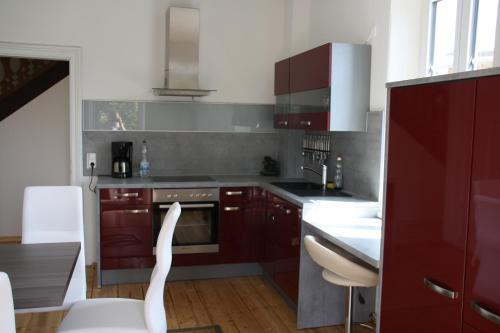 a kitchen with red cabinets and white appliances at Domitian 2 in Millstatt