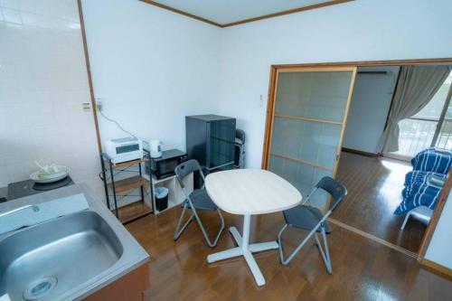 a kitchen with a sink and a table and chairs at Ohana in Minami Aso