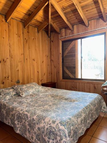 a bedroom with a bed in a room with a window at Cabaña Bosque Los Duendes in Puchuncaví