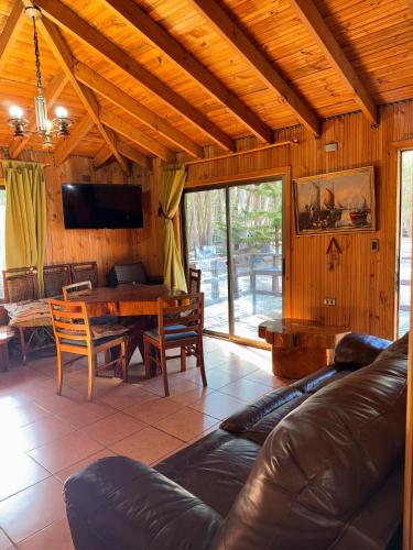 a living room with a couch and a table at Cabaña Bosque Los Duendes in Puchuncaví