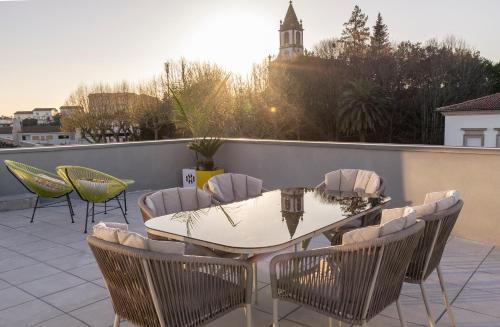 a patio with a table and chairs on a roof at Terraço da Vila in Lousada