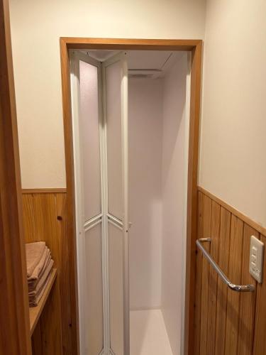 a shower in a bathroom with a glass door at Ito Ryokan in Tokyo