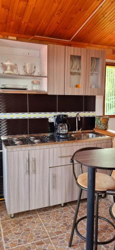 a kitchen with wooden cabinets and a table and a table and chairs at Apartamento Temático Rancho Texas in La Mesa