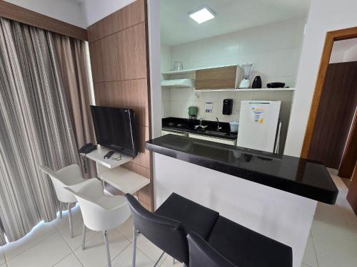 a kitchen with a counter with chairs and a counter top at Apartamentos em Rio Quente com maravilhosa área de lazer e excelente localização in Rio Quente