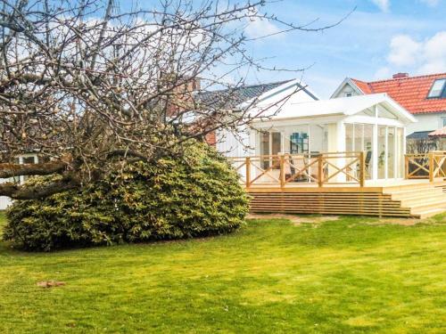 a white house with a porch and a yard at 4 star holiday home in SKÅNE VEJBYSTRAND in Vejbystrand