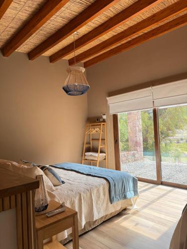 a bedroom with a bed and a window at Elegante Cabaña en Purmamarca in Purmamarca