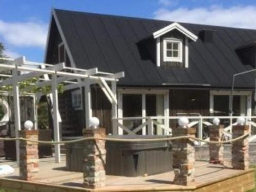 a house with a black roof and a wooden deck at 4 star holiday home in Drottningskär in Drottningskär