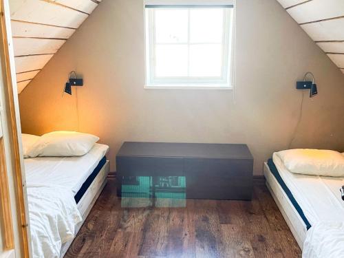 a attic bedroom with two beds and a window at 4 star holiday home in Drottningskär in Drottningskär