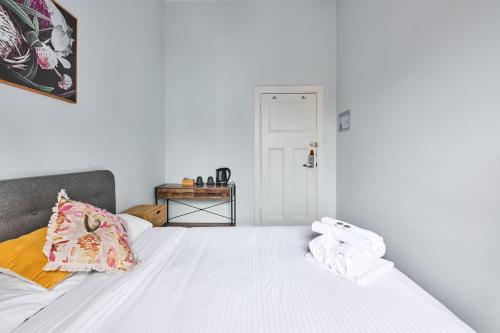 a bedroom with a white bed with towels on it at College Lawn Hotel in Melbourne