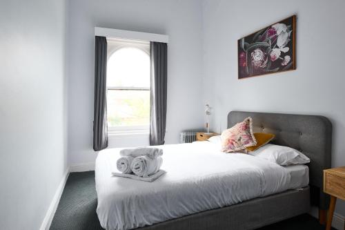 a bedroom with a bed with two towels on it at College Lawn Hotel in Melbourne
