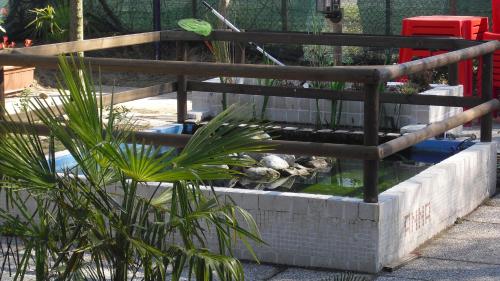 a fish pond in a brick wall with plants at Camping Klaus in Cavallino-Treporti